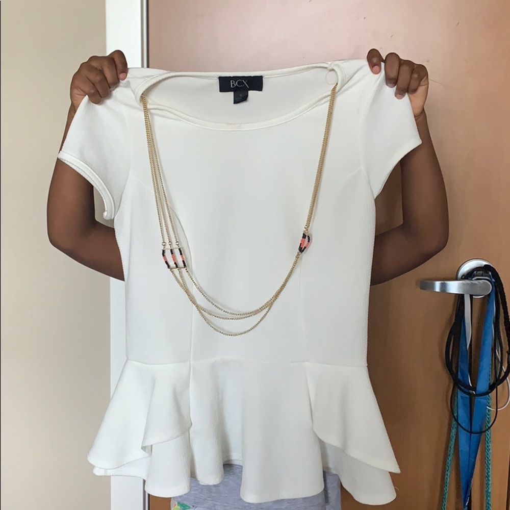 A white blouse with an attached gold necklace.